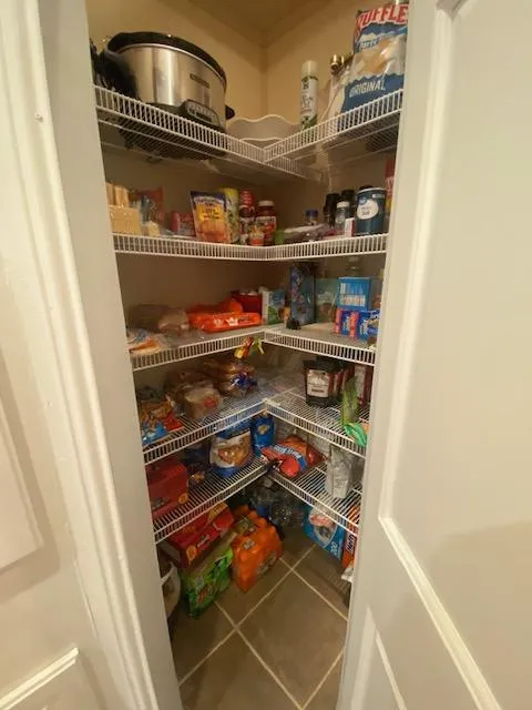 Slide: The Image of Well-stocked pantry with various food items and appliances on wire shelves. - 11