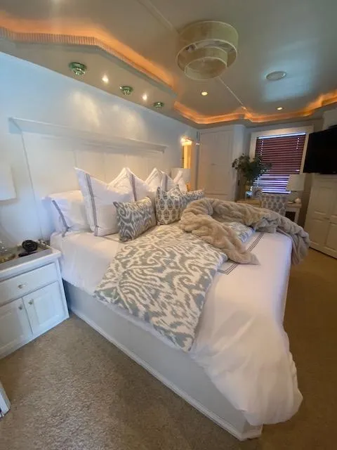 Slide: The Image of Luxurious bedroom in a 2006 Fantasy houseboat with elegant decor and ambient lighting. - 19