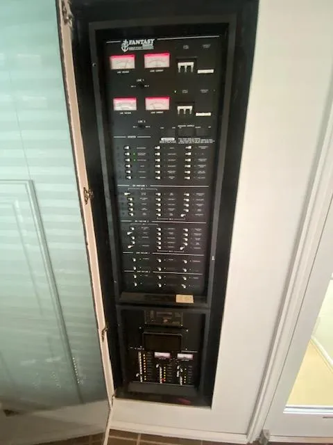 Slide: The Image of Electrical panel inside a 2006 Fantasy Houseboat, featuring multiple switches and circuit breakers. - 26