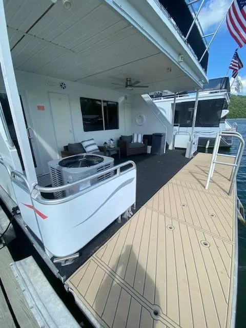 Slide: The Image of 2006 Fantasy houseboat with deck seating, docked by water, featuring American flags. - 30