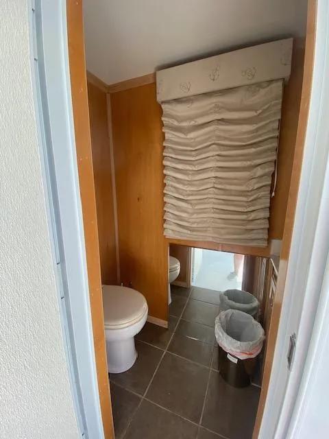 Slide: The Image of Small bathroom in a 2006 Fantasy houseboat with wooden walls and tiled floor. - 35