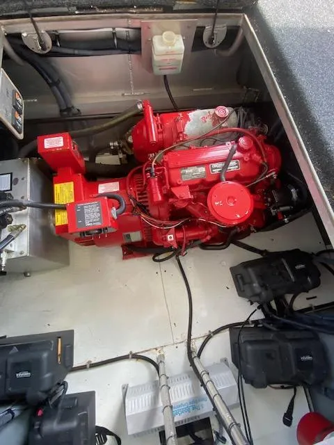 Slide: The Image of Engine compartment of a 2006 Fantasy Houseboat, featuring a red motor and various components. - 39