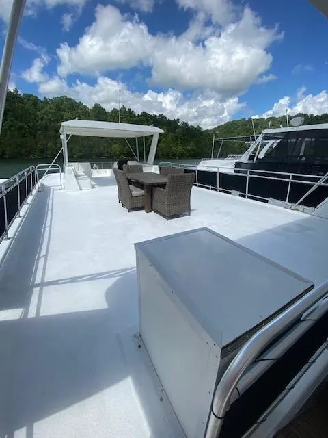 Slide: The Image of Spacious deck of a 2006 Fantasy houseboat with outdoor seating under a blue sky. - 48