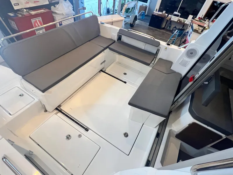 Slide: The Image of 2023 Beneteau Antares 8 boat interior with gray seating and storage compartments. - 20