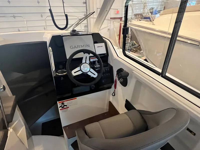 Slide: The Image of 2023 Beneteau Antares 8 cockpit with Garmin navigation system in a boat showroom. - 23