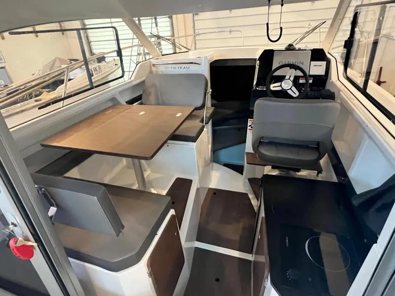 Slide: The Image of Interior of 2023 Beneteau Antares 8 boat with seating, table, and helm station. - 26