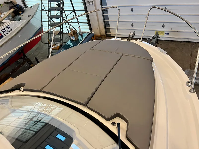 Slide: The Image of 2023 Beneteau Antares 8 boat with cushioned deck in a garage. - 29