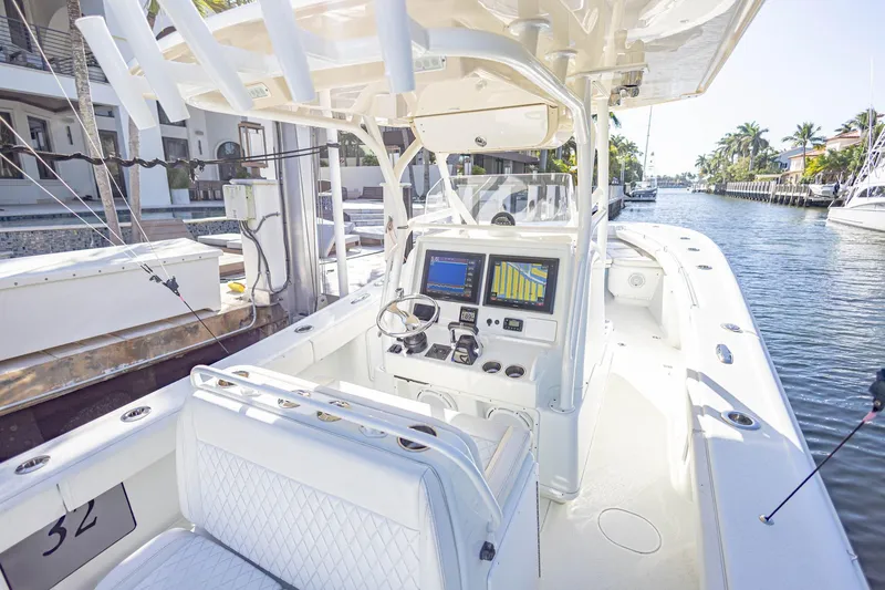 Slide: The Image of 2015 Yellowfin 32 Offshore boat with modern navigation system, docked in a sunny canal. - 14