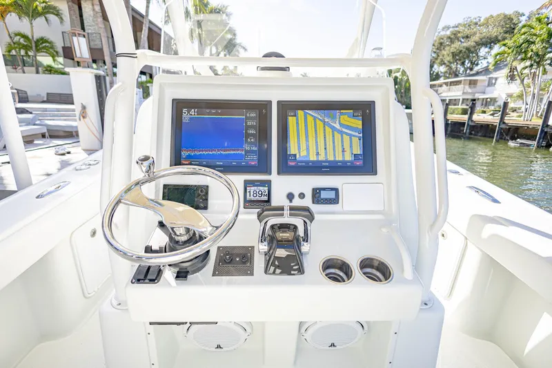 Slide: The Image of 2015 Yellowfin 32 Offshore boat dashboard with navigation screens and steering wheel. - 15