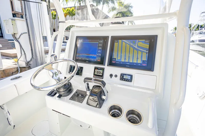 Slide: The Image of 2015 Yellowfin 32 Offshore boat dashboard with dual navigation screens and steering wheel. - 16