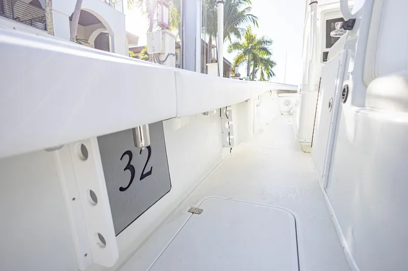 Slide: The Image of 2015 Yellowfin 32 Offshore boat interior with sleek white design and palm trees in background. - 19