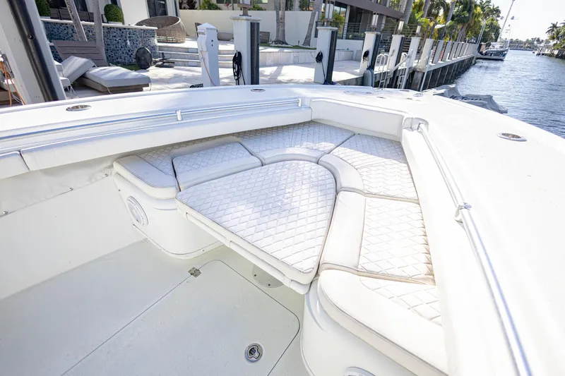 Slide: The Image of 2015 Yellowfin 32 Offshore boat with cushioned seating in a marina setting. - 25