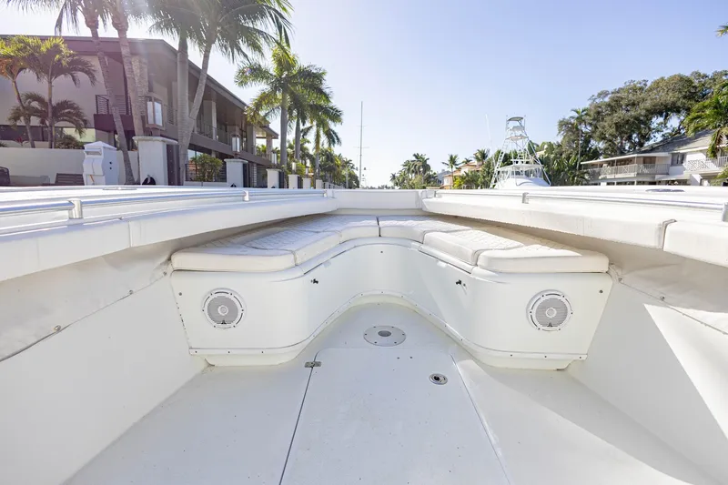 Slide: The Image of 2015 Yellowfin 32 Offshore boat interior with white seating and palm trees in background. - 27