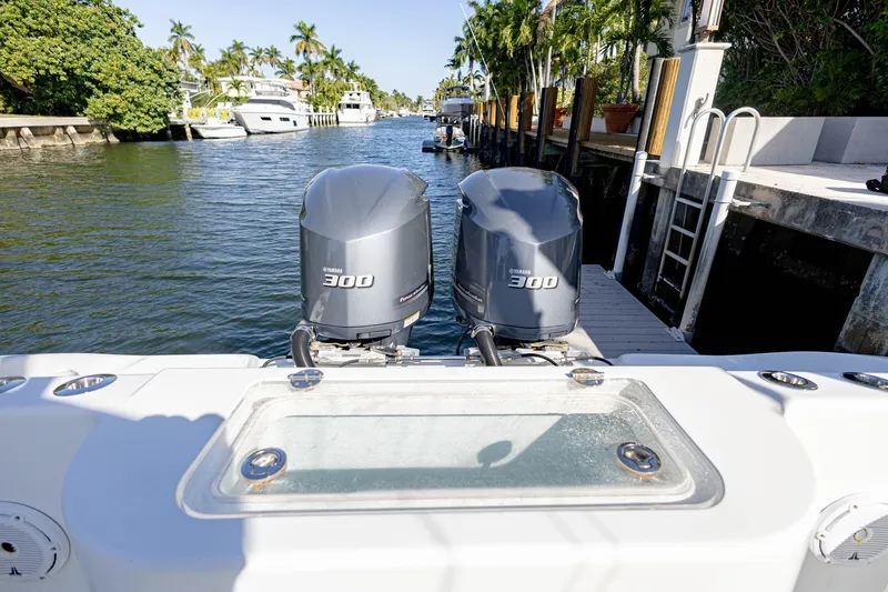 Slide: The Image of 2015 Yellowfin 32 Offshore boat with twin Yamaha 300 engines docked in a scenic canal. - 32