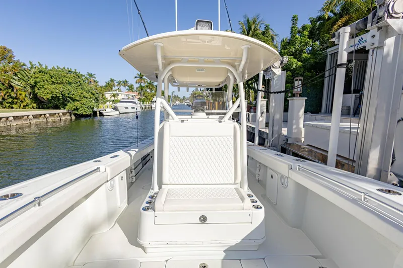 Slide: The Image of 2015 Yellowfin 32 Offshore boat docked, featuring spacious seating and sleek design. - 4