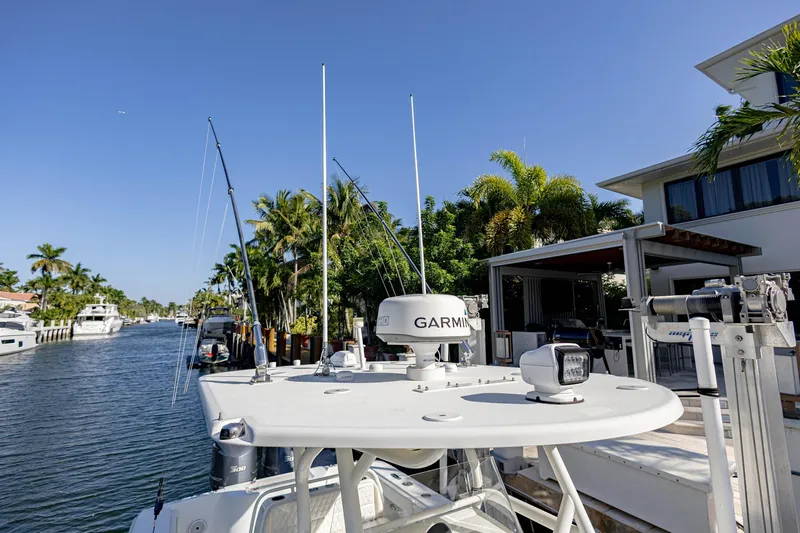 Slide: The Image of 2015 Yellowfin 32 Offshore boat docked near waterfront homes, featuring Garmin equipment. - 8