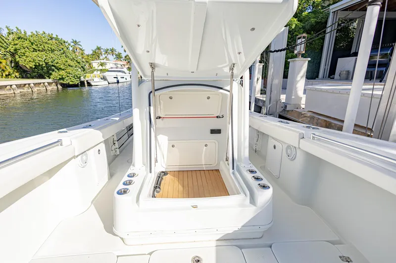 Slide: The Image of 2015 Yellowfin 32 Offshore boat interior with open storage compartment, docked by the water. - 9