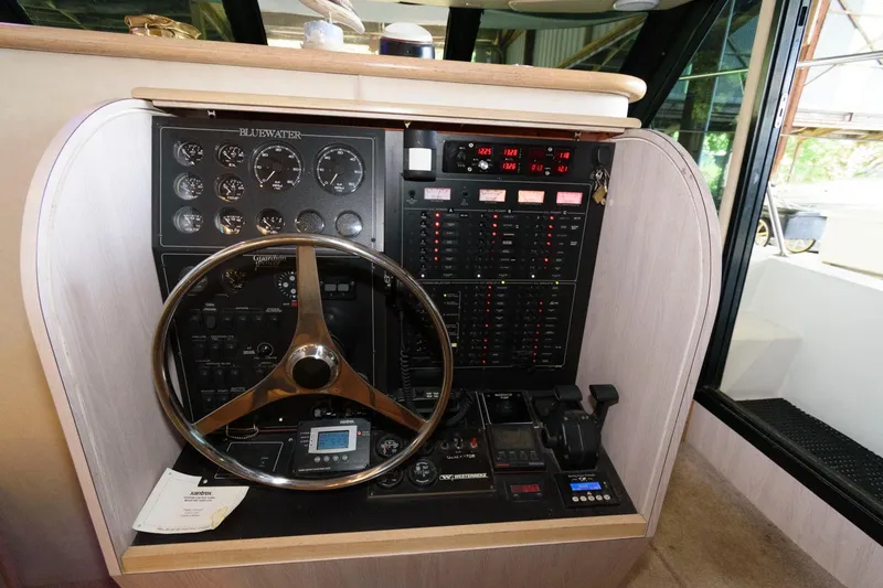 Slide: The Image of 1997 Bluewater Yachts 680 Custom Series helm station with steering wheel and control panel. - 16