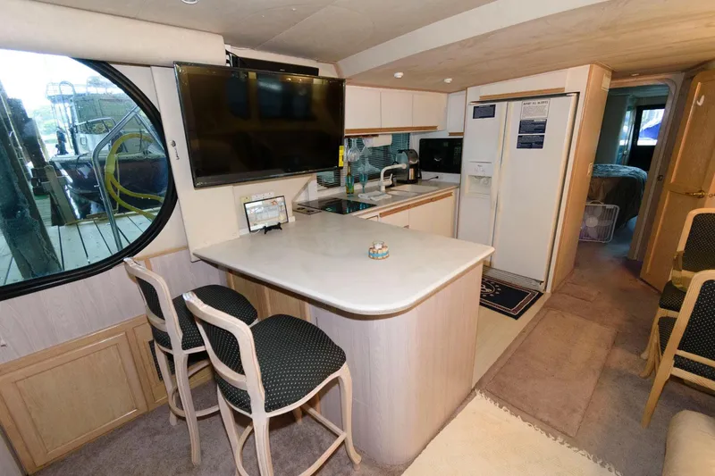 Slide: The Image of Interior of 1997 Bluewater Yachts 680 Custom Series with kitchen and seating area. - 17