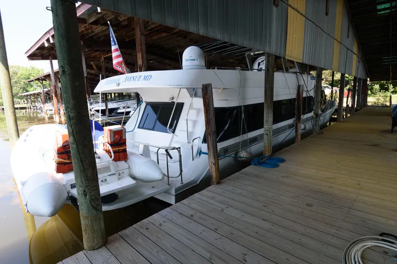 Slide: The Image of 1997 Bluewater Yachts 680 Custom Series docked under a covered marina. - 2