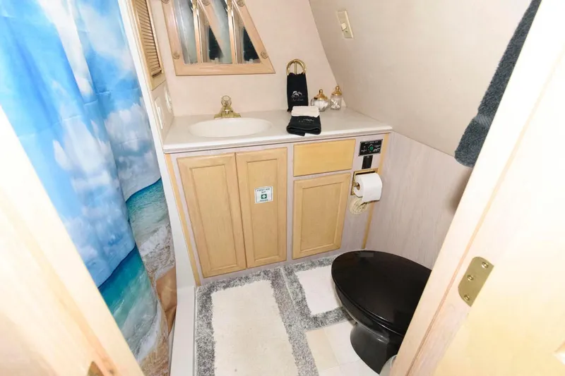 Slide: The Image of 1997 Bluewater Yachts 680 Custom Series bathroom with beach-themed shower curtain. - 24