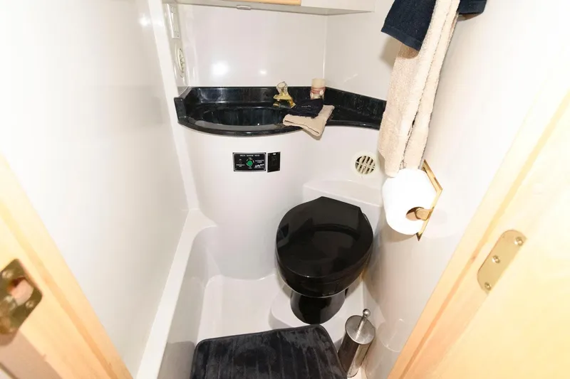 Slide: The Image of 1997 Bluewater Yachts 680 Custom Series bathroom with black toilet and countertop. - 28