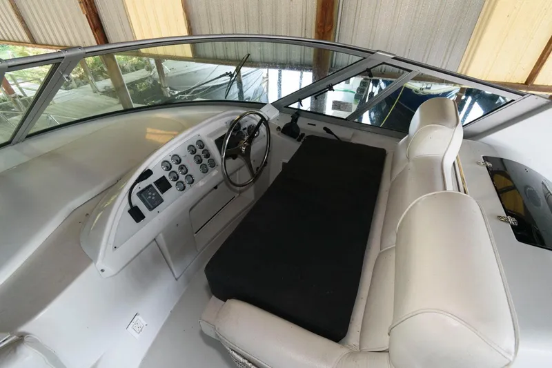 Slide: The Image of 1997 Bluewater Yachts 680 Custom Series helm with white seating and control panel. - 3