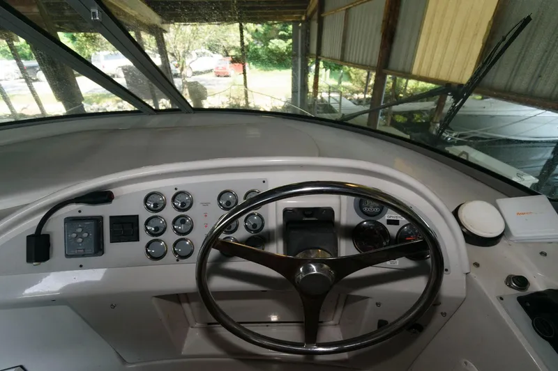 Slide: The Image of 1997 Bluewater Yachts 680 Custom Series helm with steering wheel and control panel. - 5
