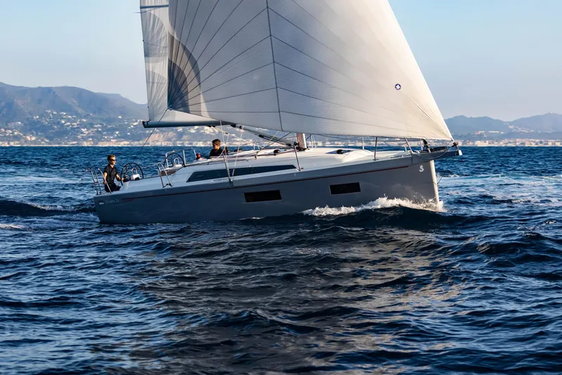 The Image of 2024 Beneteau Oceanis 34.1 sailing on open water with mountains in the background. - 0