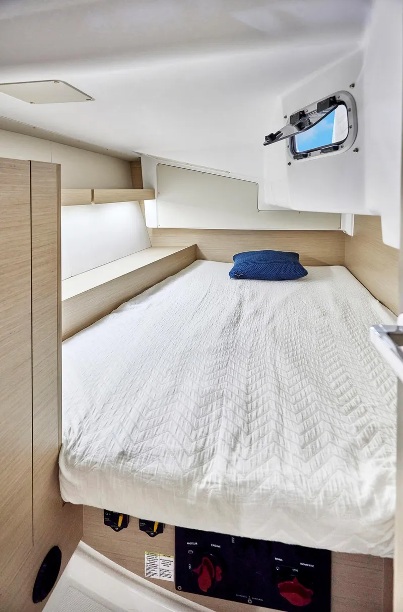 Slide: The Image of Cozy cabin interior of 2024 Beneteau Oceanis 34.1 sailboat with bed and porthole. - 22