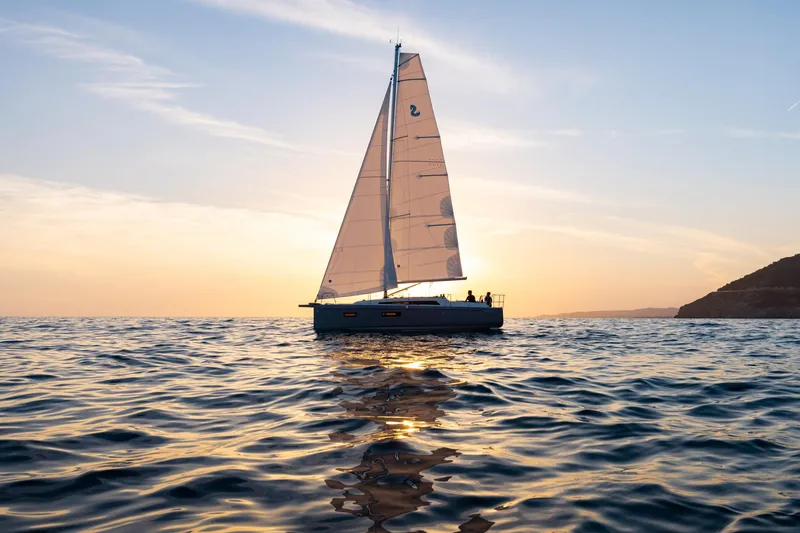 Slide: The Image of 2024 Beneteau Oceanis 34.1 sailboat on serene ocean at sunset. - 29