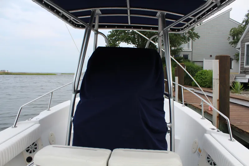 Slide: The Image of 1999 Boston Whaler Outrage 23 boat interior with covered console and seating. - 2
