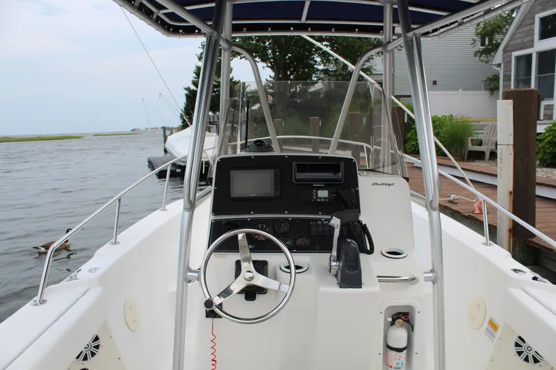 Slide: The Image of 1999 Boston Whaler Outrage 23 boat cockpit with steering wheel and navigation equipment. - 3