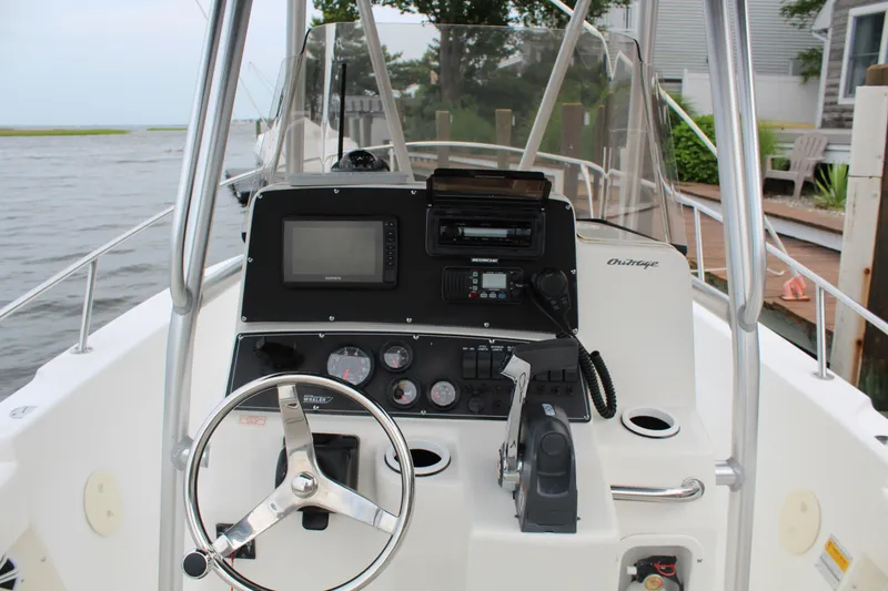 Slide: The Image of 1999 Boston Whaler Outrage 23 boat console with steering wheel and navigation equipment. - 4