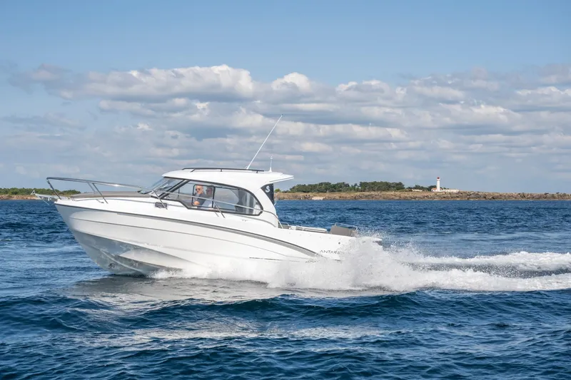 Slide: The Image of 2023 Antares 8 V2 boat cruising on open water near a lighthouse. - 22