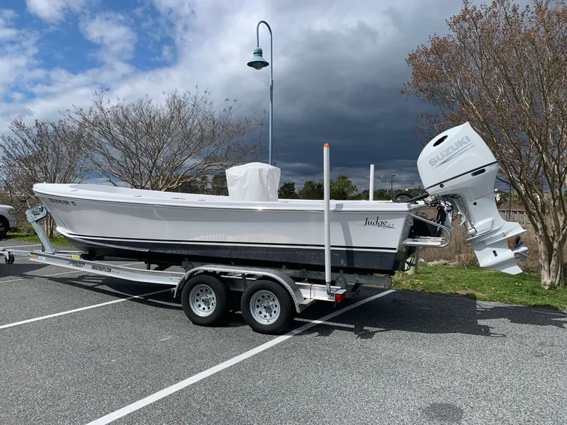 Slide: The Image of 2022 Judge 22 Shoreman boat on trailer, parked outdoors under cloudy sky. - 2