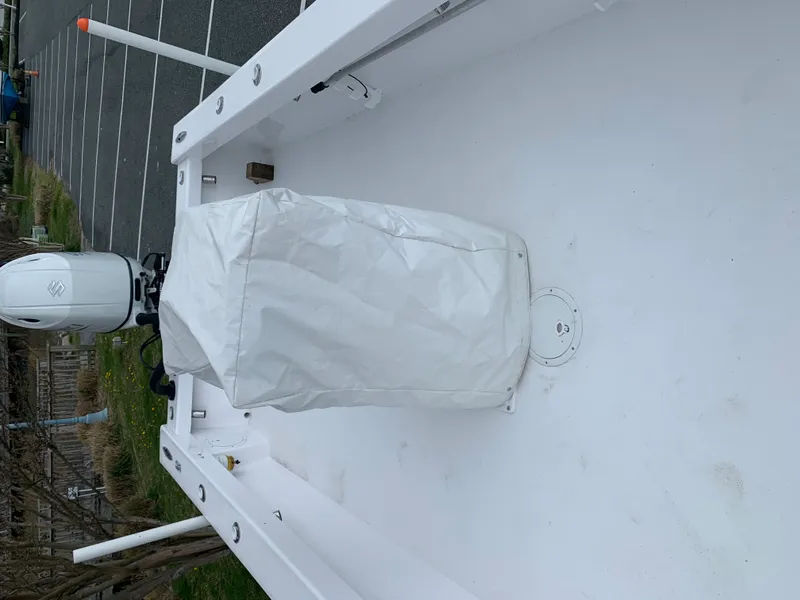 Slide: The Image of 2022 Judge 22 Shoreman boat interior with covered engine, parked on a trailer. - 24