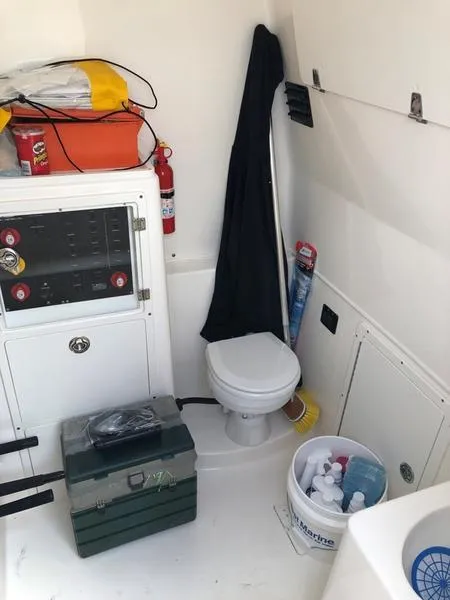 Slide: The Image of 2015 Cobia 344 Center Console boat interior with toilet, storage, and safety equipment. - 10