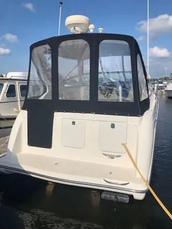 Slide: The Image of 1997 Maxum SCR3000 boat docked in marina with black canvas cover. - 11