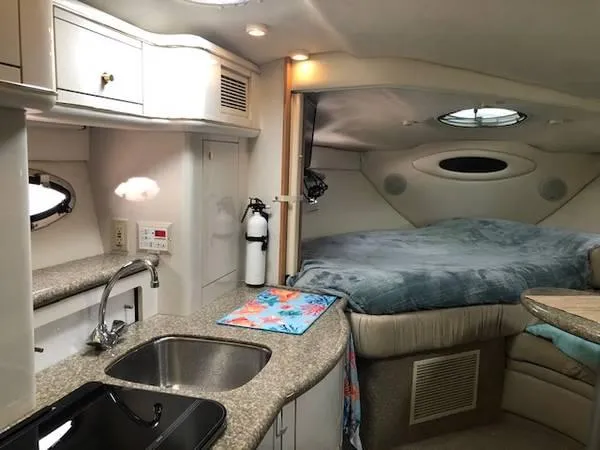 Slide: The Image of 1997 Maxum SCR3000 boat interior with kitchenette and cozy sleeping area. - 3
