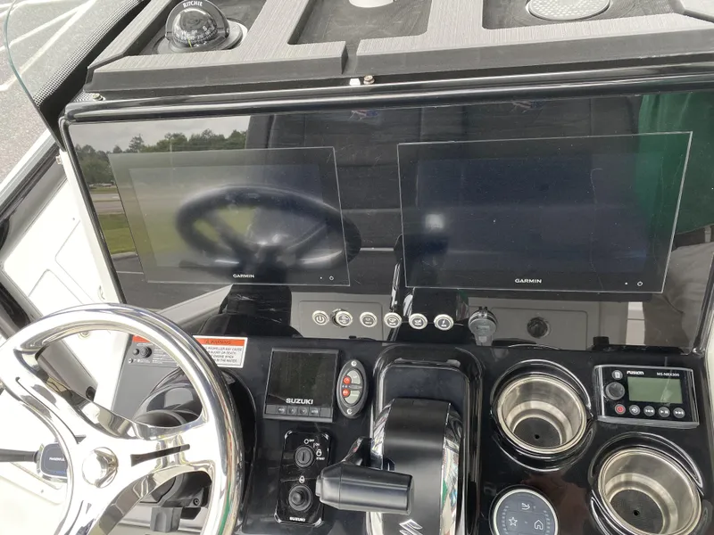 Slide: The Image of 2022 Crevalle 26 HCO boat dashboard with dual Garmin screens and steering wheel. - 25