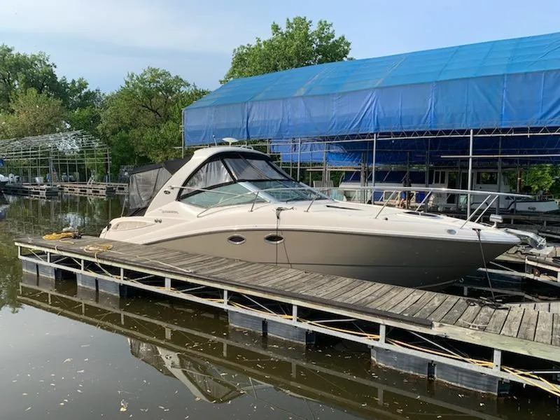 The Image of 2007 Sea Ray 290 Sundancer docked at marina with blue canopy. - 0