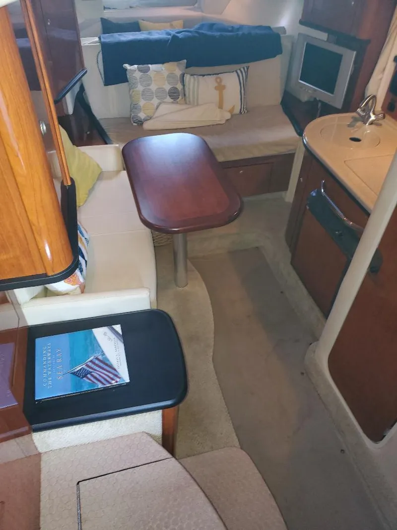 Slide: The Image of 2007 Sea Ray 290 Sundancer cabin interior with seating, table, and kitchenette. - 18