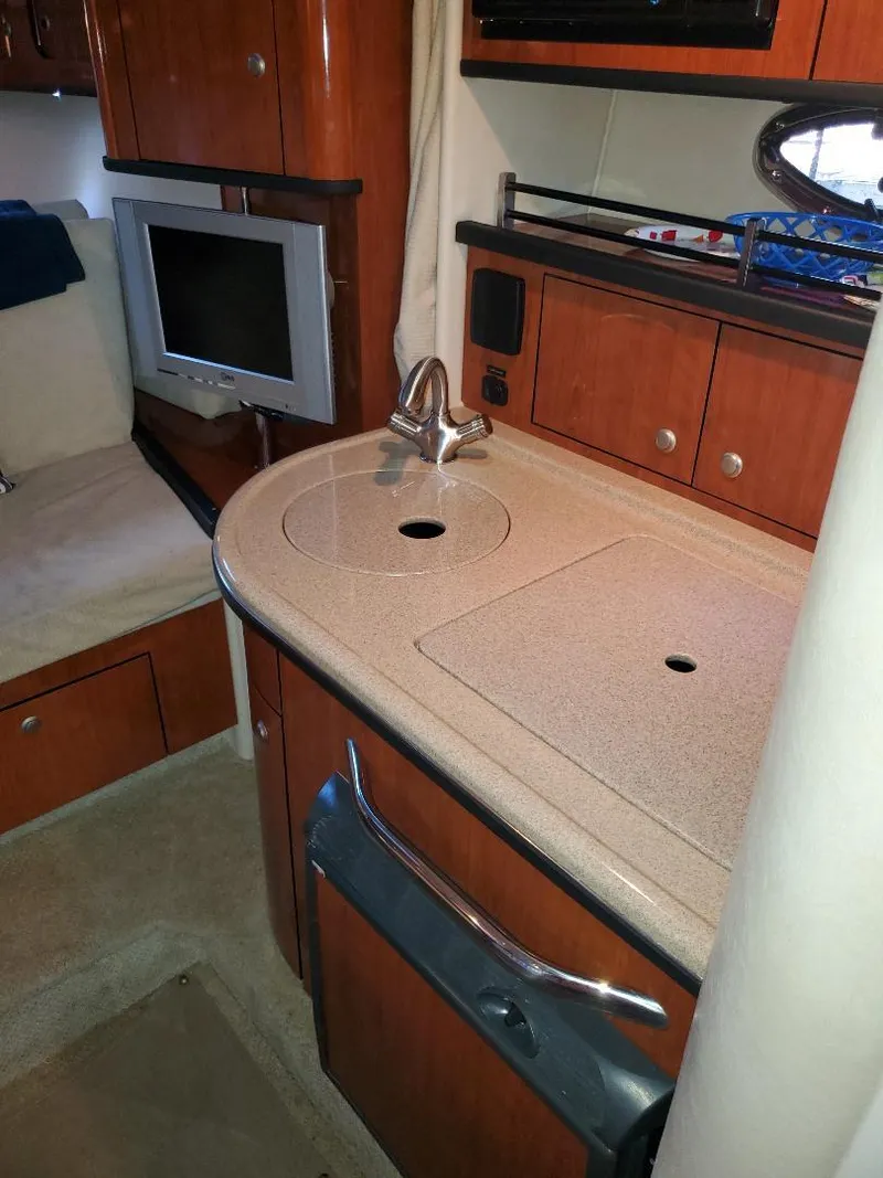 Slide: The Image of 2007 Sea Ray 290 Sundancer interior with kitchenette and TV. - 21