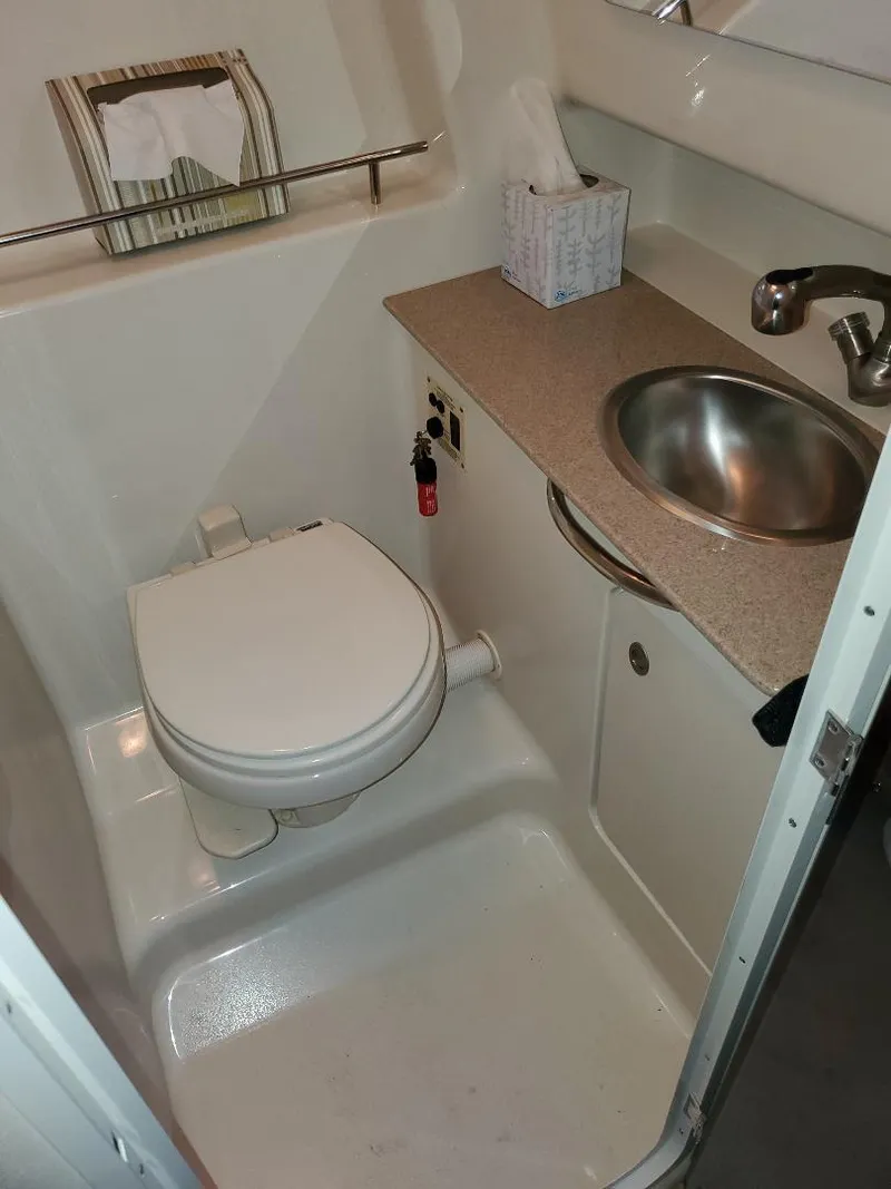Slide: The Image of Compact bathroom in 2007 Sea Ray 290 Sundancer with toilet, sink, and countertop. - 28