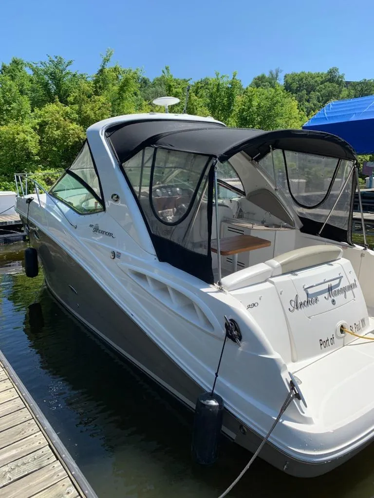 Slide: The Image of 2007 Sea Ray 290 Sundancer boat docked, featuring sleek design and canopy, surrounded by greenery. - 3