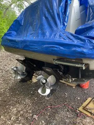 Slide: The Image of 2007 Sea Ray 290 Sundancer boat with dual propellers, partially covered by a blue tarp. - 33