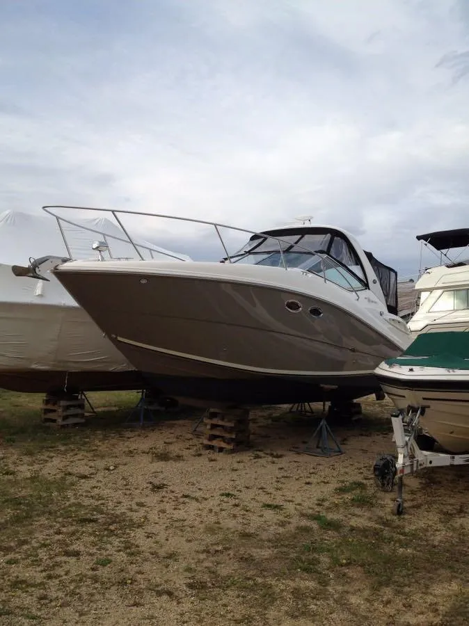 Slide: The Image of 2007 Sea Ray 290 Sundancer boat on dry dock, overcast sky background. - 4