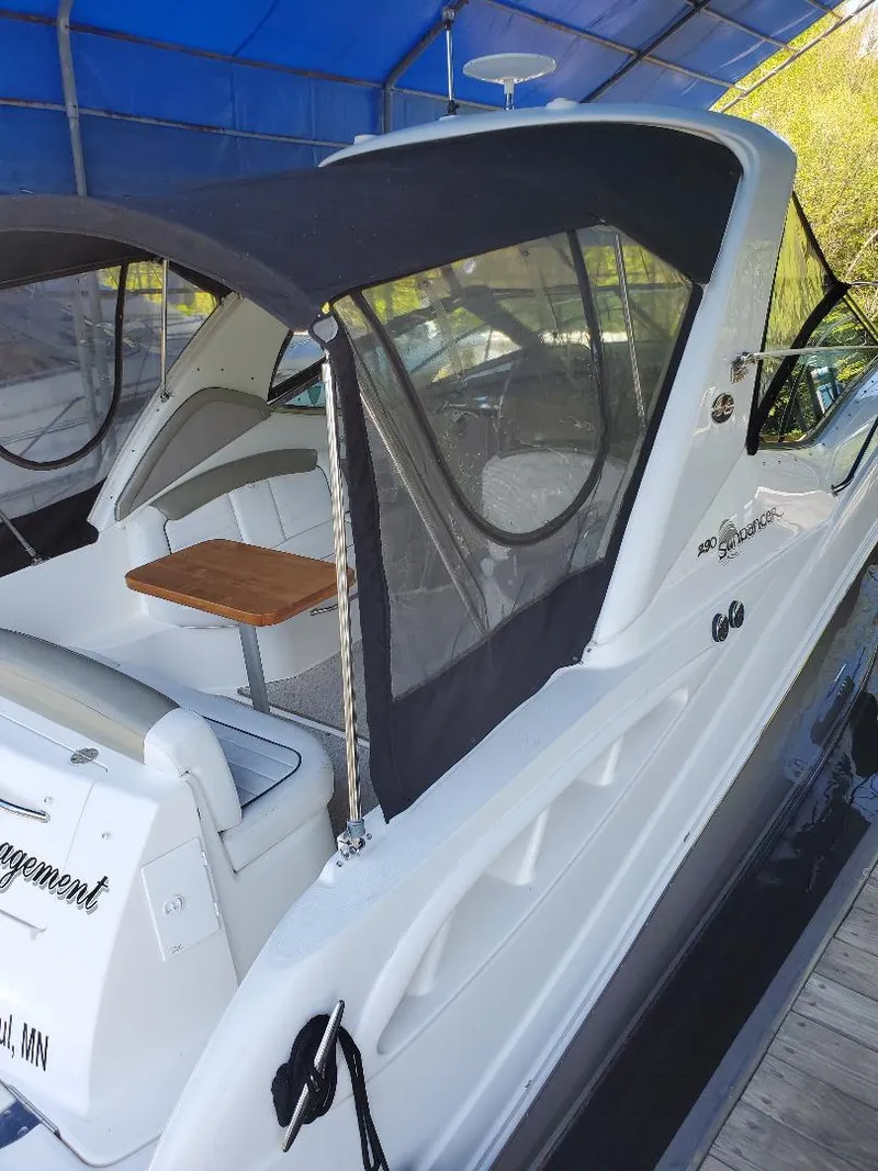 Slide: The Image of 2007 Sea Ray 290 Sundancer boat with canopy and seating, docked under a blue cover. - 6