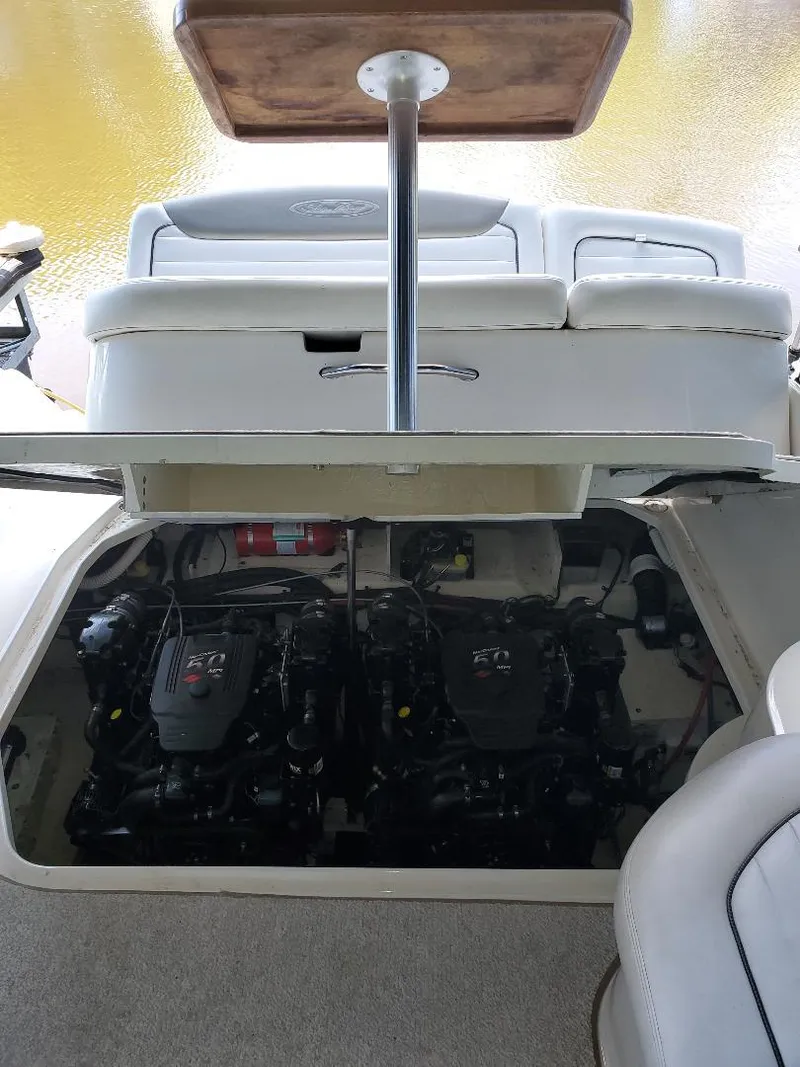 Slide: The Image of 2007 Sea Ray 290 Sundancer engine compartment with dual engines and seating area. - 8